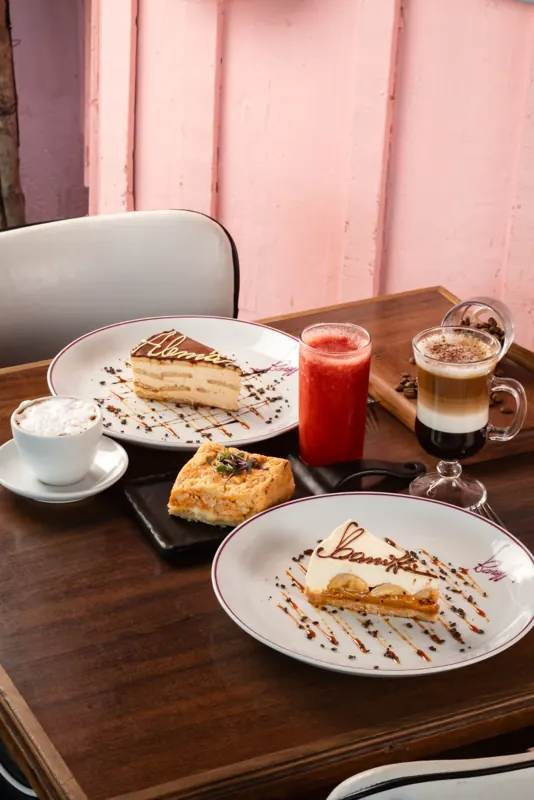 Cappuccino em camadas na mesa, com a parede rosa ao fundo