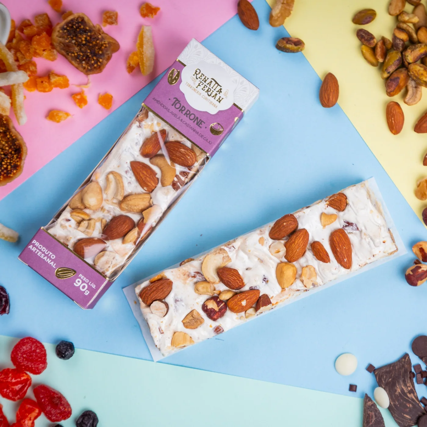 Torrones misto, pistache e frutas vermelhas cortados sobre fundo colorido